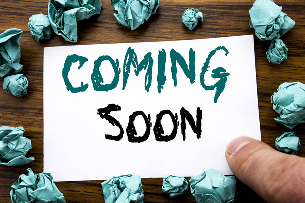 Handwriting Announcement text showing Coming Soon. Business concept for Message Future Written on sticky note paper, wooden background with folded yellow paper meaning thinking  - Photo, Image