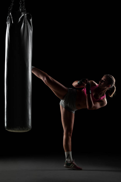 girl punching a boxing bag - Foto, afbeelding