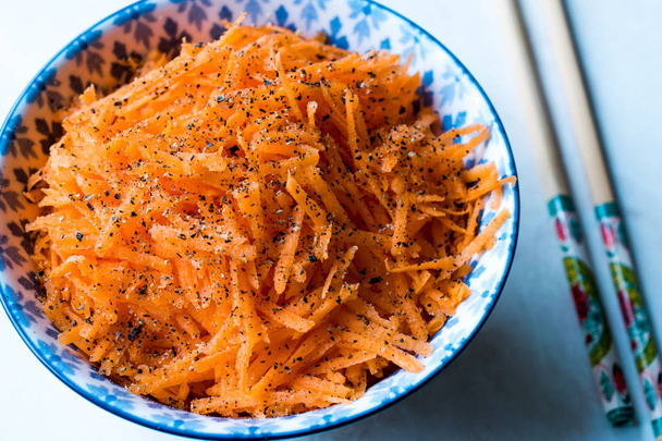 Korean Style Spicy Carrot Salad with Chopsticks in Bowl. - Foto, imagen