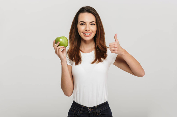 Portrait of a healthy young woman holding green apple - Photo, Image