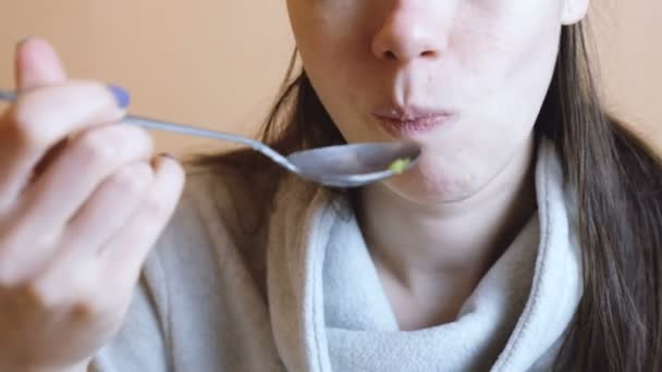 Unrecognizable woman in gray jacket eats vegetable salad. Hands and mouth close up. - Záběry, video