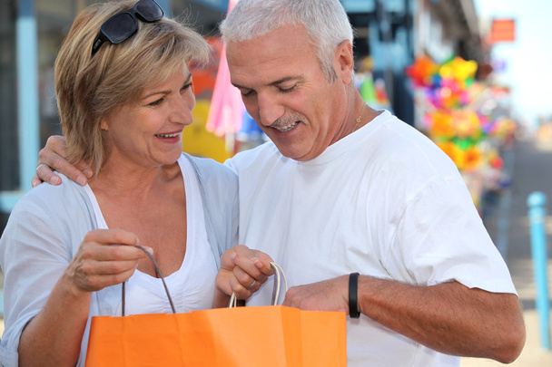 Mature couple looking at bag - Foto, afbeelding