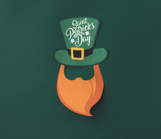 Nahaufnahme von Papercraft grünen Hut und Bart mit Heiligen Patricks Tag Schriftzug auf grünem Hintergrund - Foto, Bild