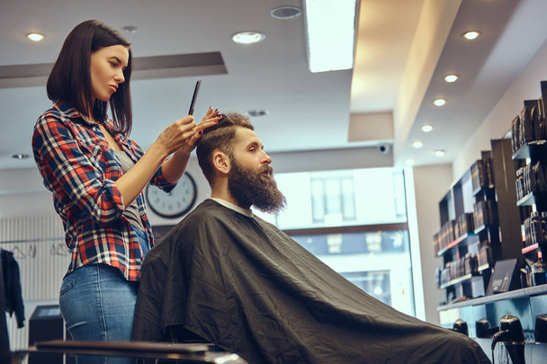 Parrucchiere professionista che fa l'acconciatura con un pettine in un barbiere
.  - Foto, immagini