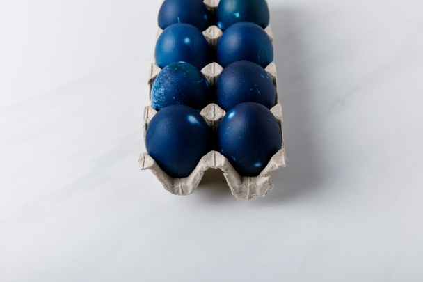 blue painted easter eggs in egg tray on white tabletop - Foto, Bild