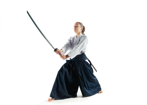 Aikido master practices defense posture. Healthy lifestyle and sports concept. Woman in white kimono on white background. - Photo, Image