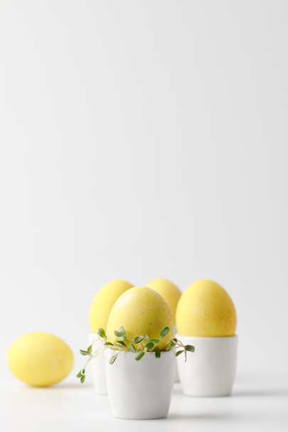 żółty malowane pisanki w jajku stoi na biały - Zdjęcie, obraz