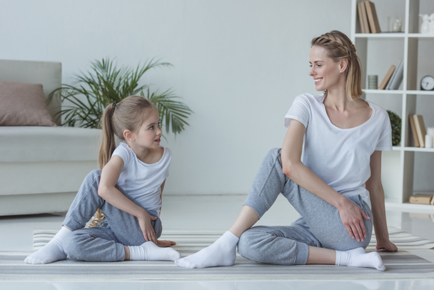 mother and daughter practicing yoga together in Marichi's pose - Photo, Image