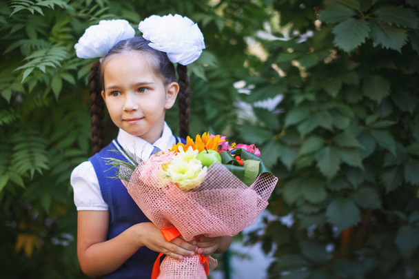 Pretty schoolgirl with a bouquet of flowers back to school - Fotoğraf, Görsel