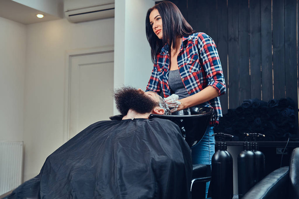 Parrucchiere professionista che lava i capelli del cliente in un barbiere
. - Foto, immagini
