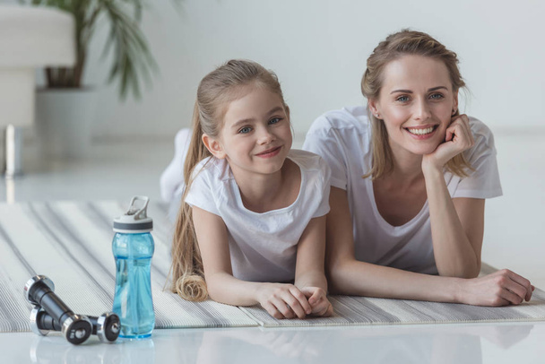 Anne ve kızı yoga paspaslar üzerine eğitimden sonra yalan mutlu uygun - Fotoğraf, Görsel