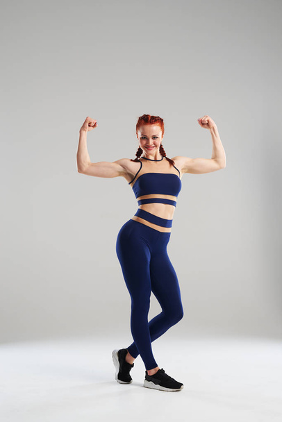 femme de sport en bleu vêtements de sport montrant biceps
 - Photo, image