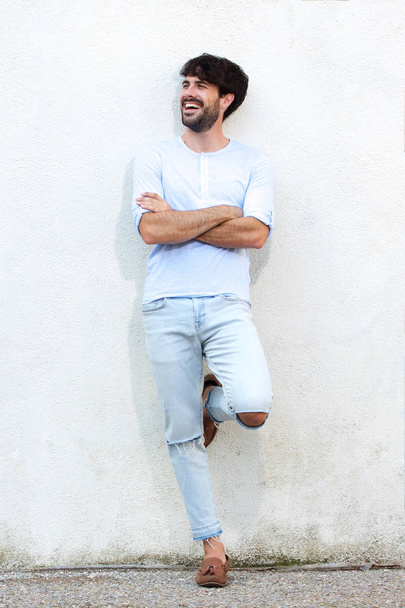 Retrato de longitud completa del modelo de moda masculino apoyado en la pared blanca
 - Foto, imagen