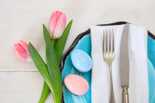 Easter table setting with pink tulips on white wooden background. Top view - Foto, Imagen