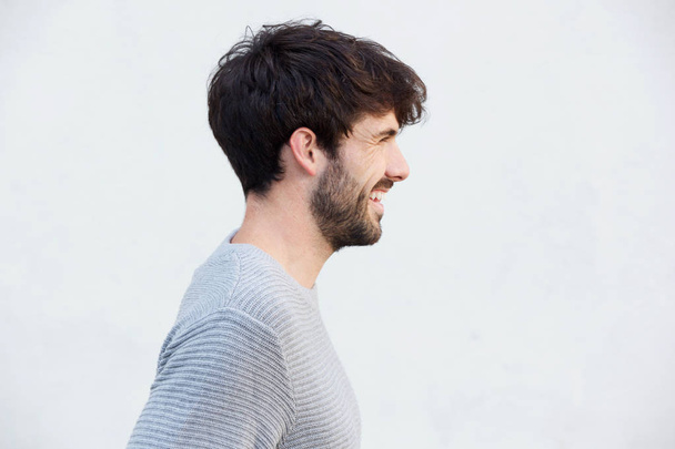 Close up lateral retrato de feliz jovem com barba contra fundo branco
 - Foto, Imagem