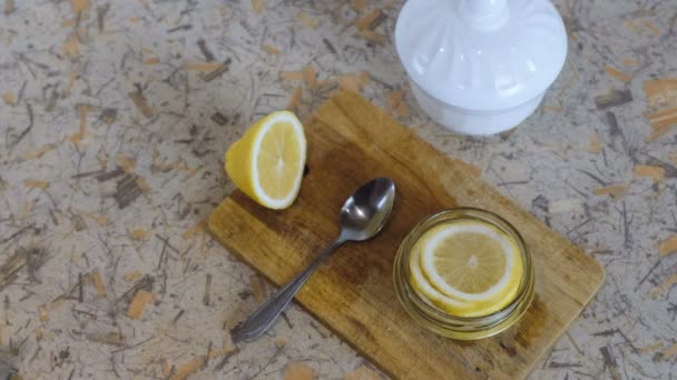 Close-up of woman hand closes the jar with slices of lemon with red lid. - Footage, Video