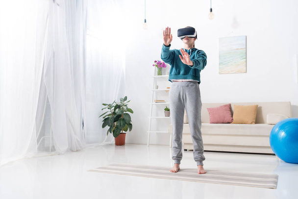 girl touching something with virtual reality headset at home - Foto, Imagen