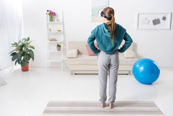 rear view of girl exercising with virtual reality headset at home - Zdjęcie, obraz