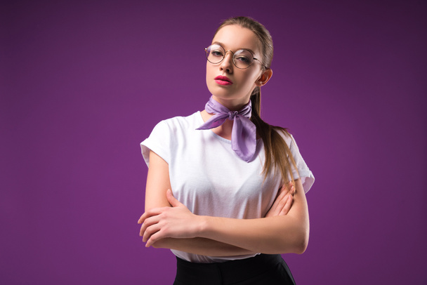 stylish girl with crossed arms looking at camera isolated on purple - Photo, Image