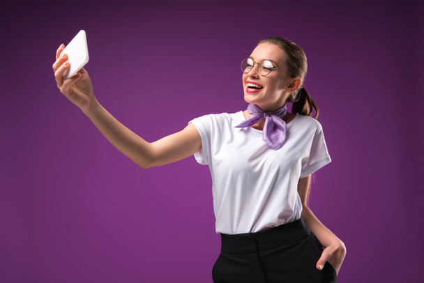 girl taking selfie with smartphone isolated on purple - Fotoğraf, Görsel