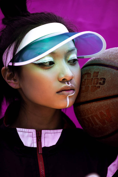 Modern portrait of beautiful young sporty asian girl with basketball - Фото, изображение