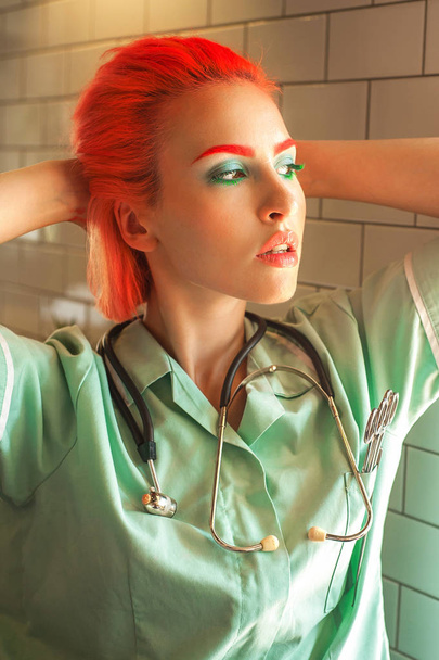 Bright redhead female medical student with makeup and stethoscope - Фото, зображення