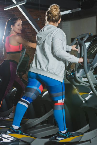 women training on treadmill at gym and looking on each other - Foto, imagen