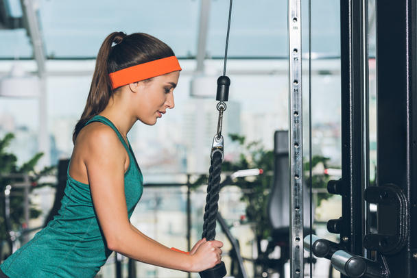 sporty woman exercising on training apparatus  at gym - Фото, зображення