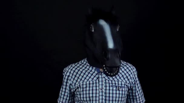 Homem com uma máscara de cavalo acena com a cabeça dançando isolado em um fundo preto câmera lenta
 - Filmagem, Vídeo