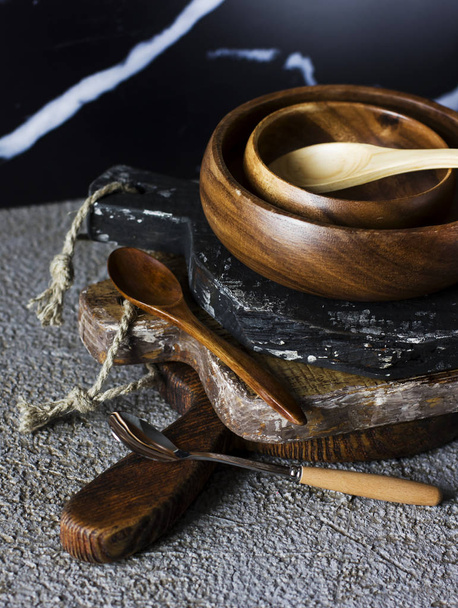 Wooden boards, bowl and spoons on grey concrete background - Valokuva, kuva