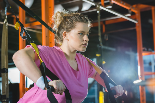 overweight woman training on resistance bands at gym - Photo, Image