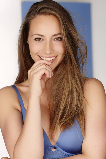 Young woman in blue bra, smiling at camera - Foto, afbeelding