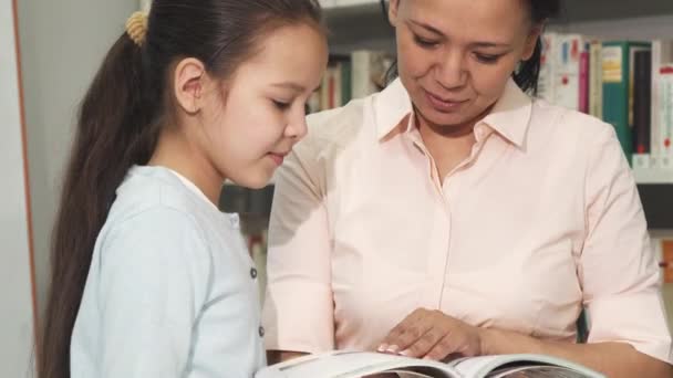 Anne ve kızı kitaplar kütüphane veya kitap seçimi - Video, Çekim