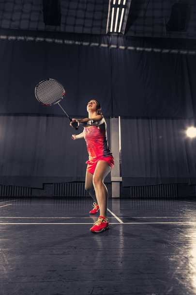 Young woman playing badminton at gym - Φωτογραφία, εικόνα