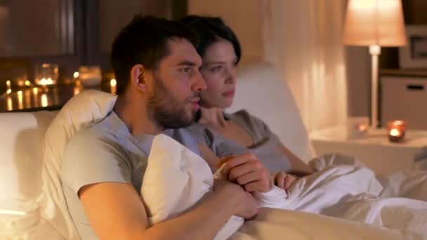 scared couple watching horror movie on tv at home - Video