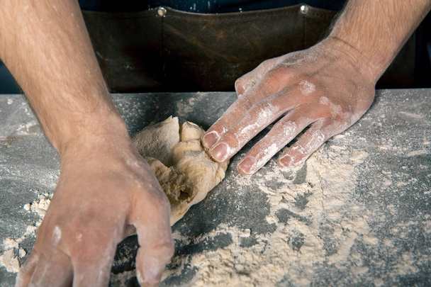 Las manos del chef amasando la masa
 - Foto, imagen