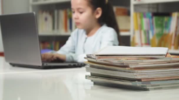 Μικρό κορίτσι που χρησιμοποιούν φορητό υπολογιστή στο σχολείο μελετώντας κάνει την εργασία - Πλάνα, βίντεο