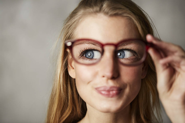 Portrait of woman with big blue eyes holding glasses looking aside - Fotografie, Obrázek