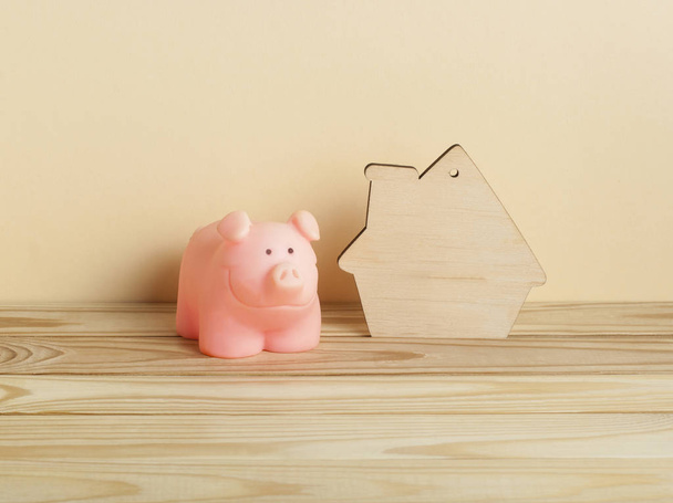 Домашні заощадження, бюджет та концепція власності. Модель будинку і скарбнички на дерев'яному столі
. - Фото, зображення