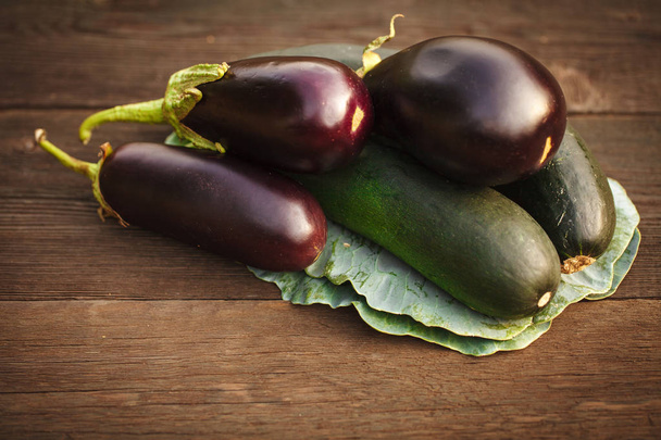 Fresh zucchini and eggplant on a wooden table. Background - Valokuva, kuva