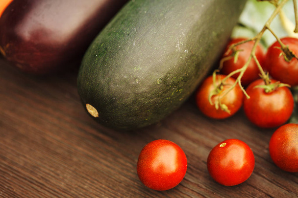 Fresh eggplant with tomato on a wooden table. Autumn concept. - 写真・画像