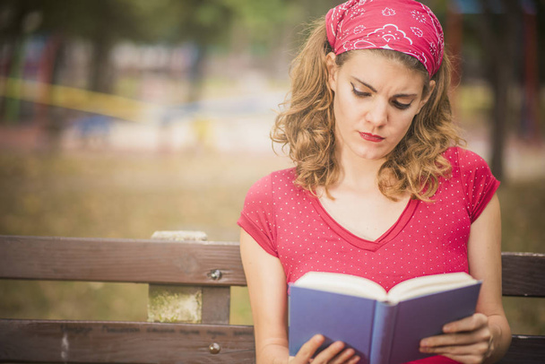 Απολαμβάνοντας ένα βιβλίο σε ένα πάρκο, vintage στυλ - Φωτογραφία, εικόνα