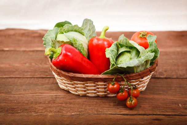 Basket with fresh vegetables on a wooden table. Tomatoes, Bulgar - Fotó, kép