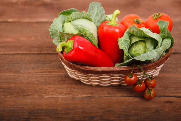 Basket with fresh vegetables on a wooden table. Tomatoes, Bulgar - Φωτογραφία, εικόνα