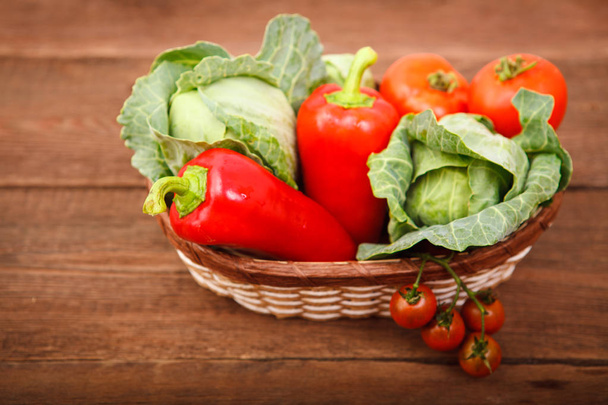 Basket with fresh vegetables on a wooden table. Tomatoes, Bulgar - Fotó, kép