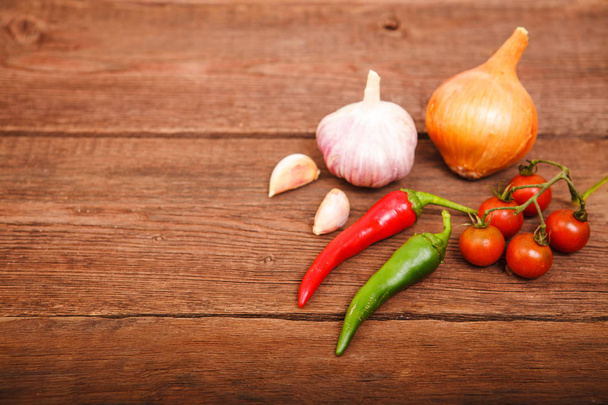 Fresh vegetables on a wooden background. Garlic, onion, chili an - Foto, Bild