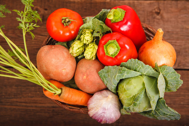 Fresh vegetables lie in a basket on a wooden background. Bulgari - Zdjęcie, obraz