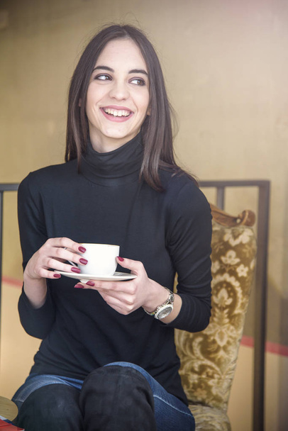Young woman enjoying some coffee in a cafe - Fotoğraf, Görsel