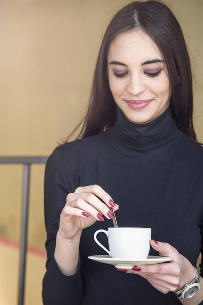 Young woman enjoying some coffee in a cafe - Foto, afbeelding