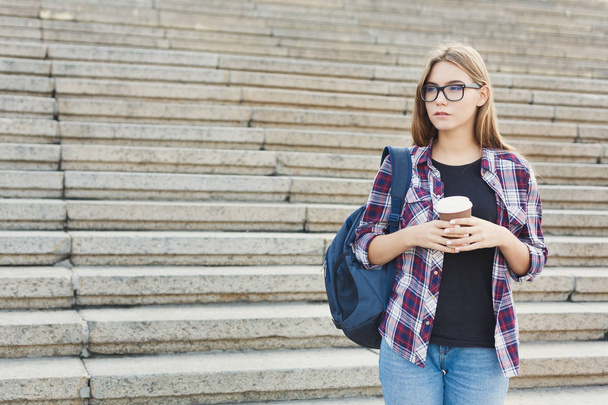 Studente ragazza in piedi con tazza di caffè all'aperto
 - Foto, immagini